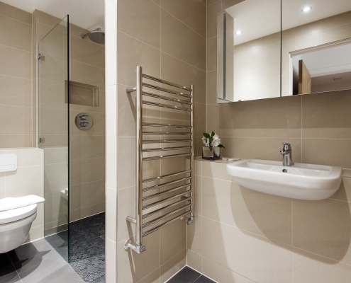 Modern bathroom with white tiles, large mirror, and elegant fixtures