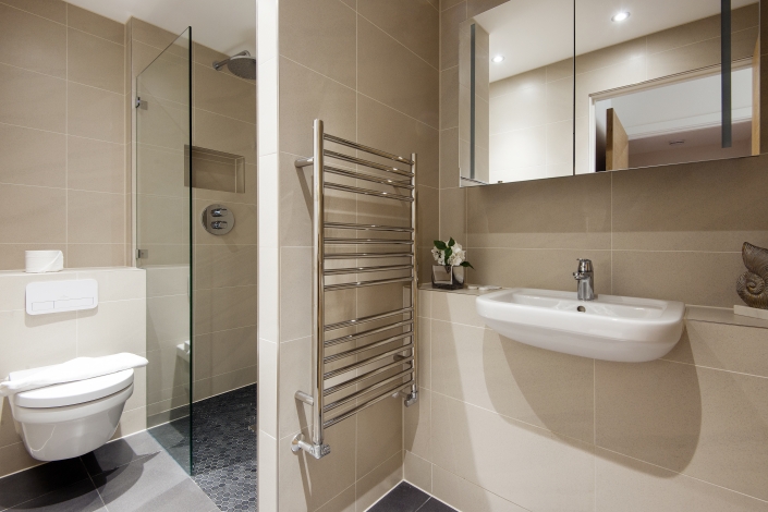 Modern bathroom with white tiles, large mirror, and elegant fixtures